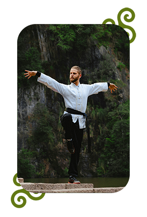 Homme pratiquant le Tai Chi près de l'eau en plein air